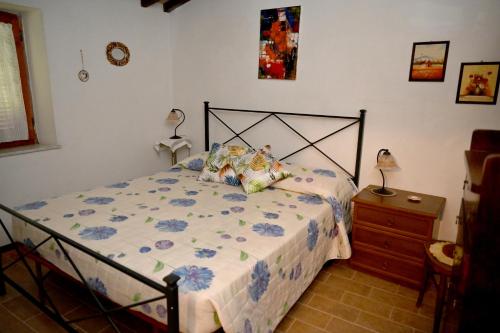a bedroom with a bed and a wooden dresser with a night stand at IL TUFO E LA CASCATA in Pitigliano