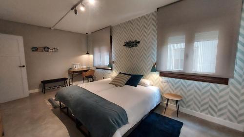 ein Schlafzimmer mit Bett, Schreibtisch und Fenster in der Unterkunft Morriña Atlantica Loft in Pontevedra