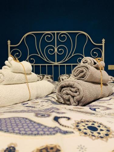 a blue and white bed with towels on it at Claves Claustri - Appartamento storico con balcone in Sarteano