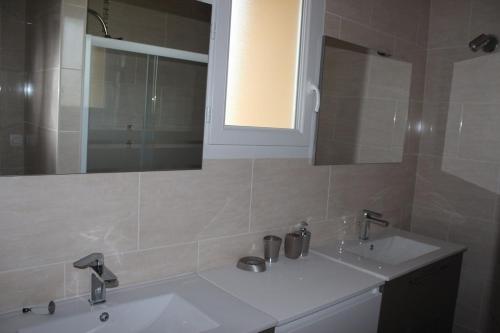 une salle de bain avec deux lavabos et un miroir dans l'établissement Gite de Born avec piscine privée au coeur de la campagne, à Born-de-Champs