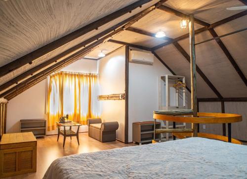 ein Schlafzimmer im Dachgeschoss mit einem Bett und einem Stuhl in der Unterkunft Casa di legno italiana in Bento Gonçalves