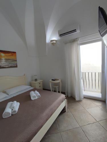 a bedroom with a bed and a large window at B&B Punta Cutieri in Gallipoli