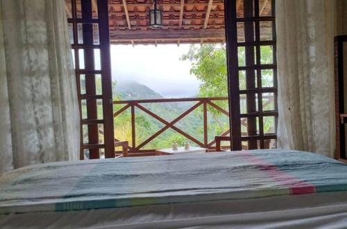 a bed in a room with a large window at Casa Serra Negra in Bezerros
