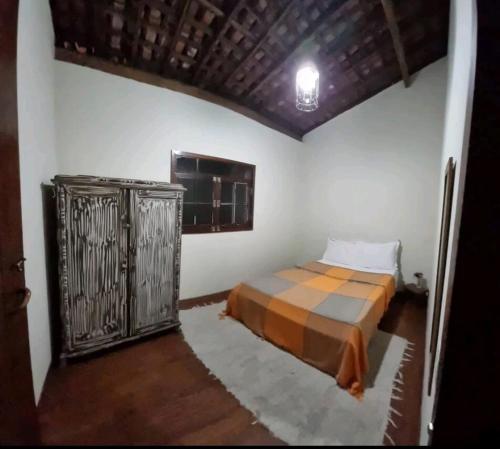een slaapkamer met een bed in de hoek van een kamer bij Casa Serra Negra in Bezerros