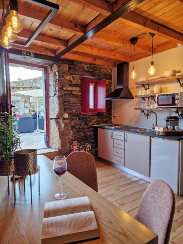 a kitchen with a wooden table with a glass of wine at Sweet Côa in Sabugal