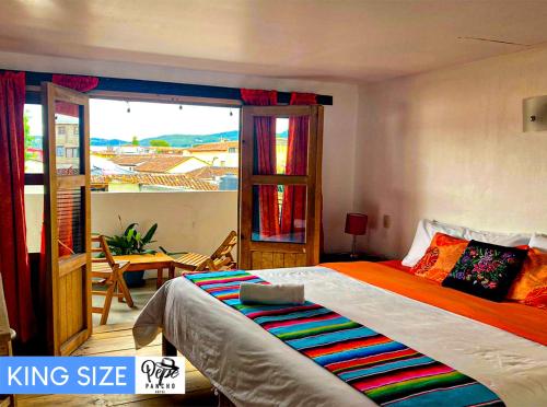 a bedroom with a king size bed and a balcony at Hotel Pepe Pancho in San Cristóbal de Las Casas