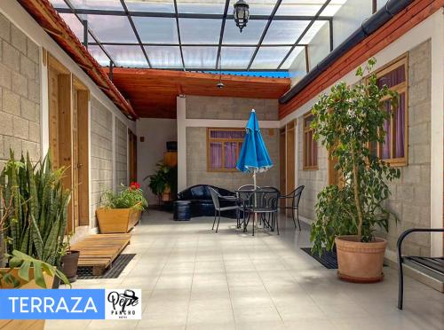 a patio with a table and a blue umbrella at Hotel Pepe Pancho in San Cristóbal de Las Casas