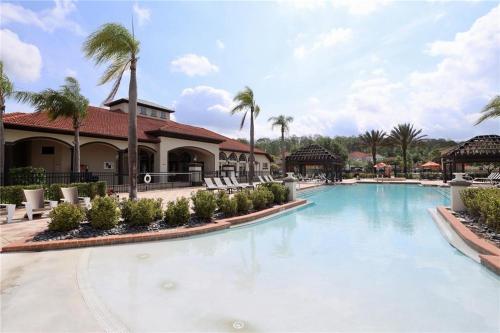 a swimming pool at a resort with chairs and palm trees at BellaVida Orlando in Kissimmee