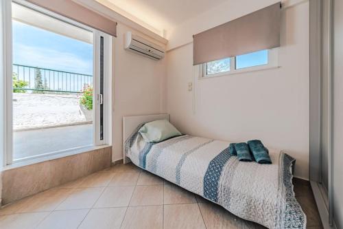 a bedroom with a bed and a large window at George residence Attica Riviera in Kalívia Thorikoú