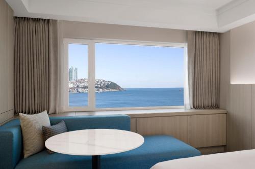 a room with a table and a view of the ocean at The Westin Josun Busan in Busan