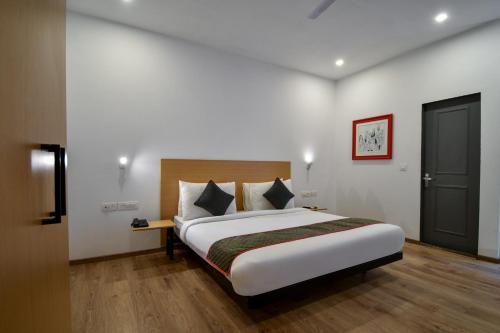 a bedroom with a large bed in a room at Super Townhouse 596 Hotel KG Estate in Jaipur