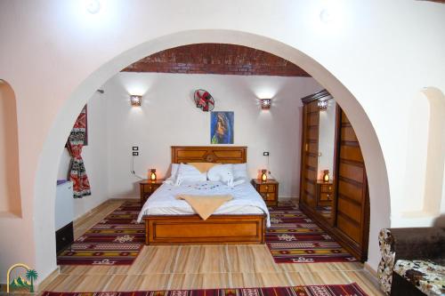 a bedroom with a bed in an archway at amzran hotel siwa in Siwa