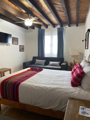 a bedroom with a large bed and a couch at Hotel La Lejona in San Miguel de Allende