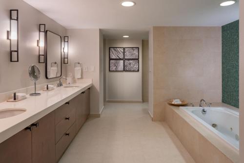 a bathroom with two sinks and a bath tub and a tubermott at Sheraton Puerto Rico Resort & Casino in San Juan