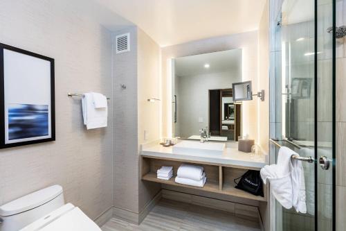 a bathroom with a sink and a toilet and a mirror at Courtyard by Marriott Los Angeles Monterey Park in Monterey Park