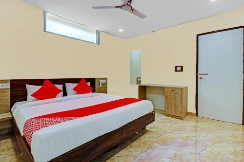 a bedroom with a large bed with red pillows at Ab7 Residency Near Miraj Cinemas - Shalini Shivani in Hyderabad