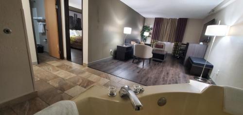 Habitación de hotel con lavabo y sala de estar. en Super 8 by Wyndham Sterling Heights/Detroit Area, en Sterling Heights