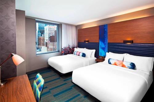 a hotel room with two beds and a window at Aloft Manhattan Downtown - Financial District in New York