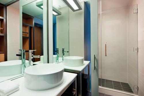 a bathroom with two sinks and a large mirror at Aloft Manhattan Downtown - Financial District in New York