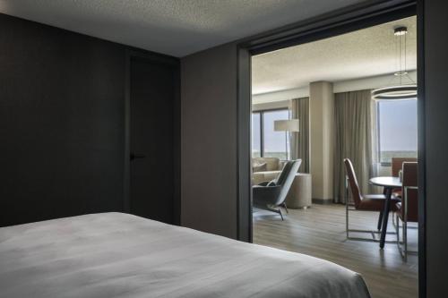 a hotel room with a bed and a dining room at Chicago Marriott Schaumburg in Schaumburg
