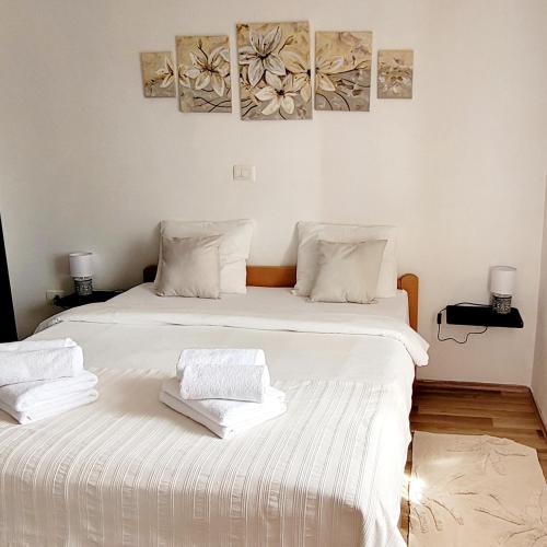2 Betten in einem Zimmer mit weißer Bettwäsche in der Unterkunft Apartman Rocky in Petrovija