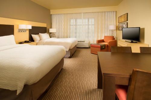 a hotel room with two beds and a television at TownePlace Suites by Marriott Dallas DFW Airport North/Grapevine in Grapevine