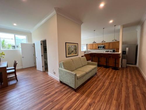 a living room with a couch and a kitchen at Cozy Custom Vacation Home in Kaneohe