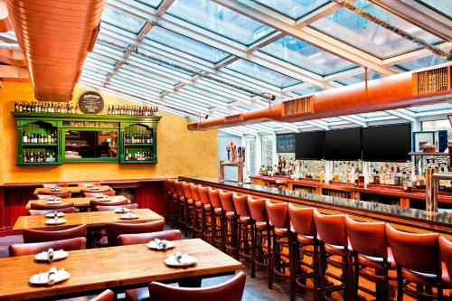 a restaurant with wooden tables and chairs and a bar at Four Points by Sheraton Manhattan Chelsea in New York