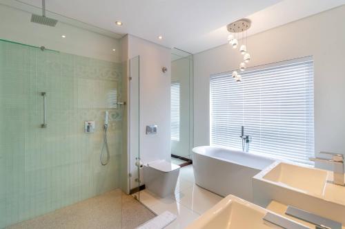 ein Bad mit einer Badewanne, einer Dusche und einem Waschbecken in der Unterkunft Protea Hotel by Marriott Mossel Bay in Mossel Bay