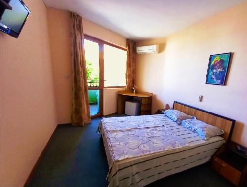 a bedroom with a bed and a window at Family Hotel Amore in Byala