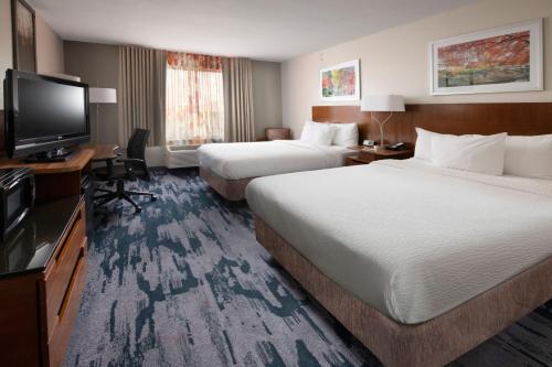 a hotel room with two beds and a flat screen tv at Fairfield by Marriott Inn & Suites Fossil Creek in Fort Worth