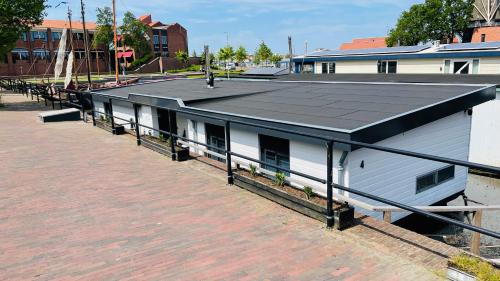 a white building with a black roof on a street at Woonboot 4 Harderwijk in Harderwijk