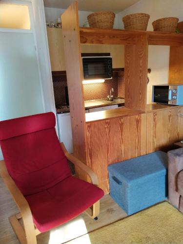une chaise rouge dans une cuisine équipée d'un four micro-ondes dans l'établissement La Foux d'Allos joli studio familial 2-4 pers, ski et randonnées, à Allos