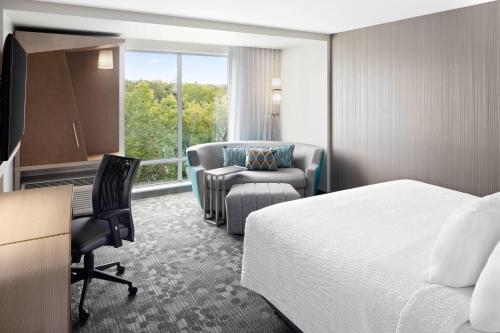 a hotel room with a bed and a desk and a chair at Courtyard by Marriott Albany Troy/Waterfront in Troy