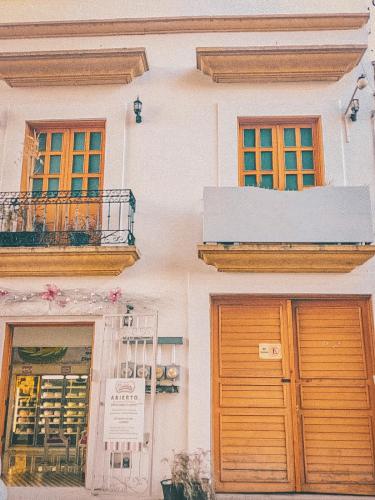 a white building with two windows and two doors at Hostel Casa Maguey in Oaxaca City