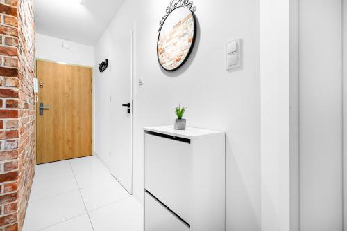 Habitación blanca con espejo en la pared en Apartament Grunwaldzka 35, en Olsztyn