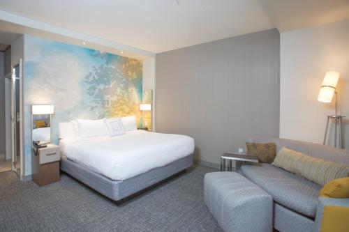 a hotel room with a bed and a couch at Courtyard by Marriott Albion in Albion
