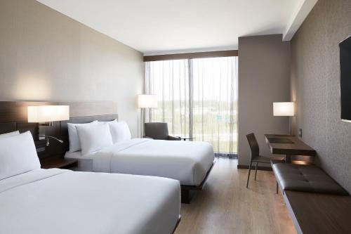 een hotelkamer met 2 bedden en een raam bij AC Hotel by Marriott Minneapolis West End in Minneapolis