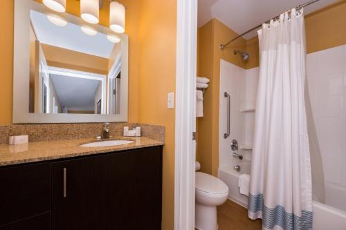 a bathroom with a sink and a toilet and a mirror at TownePlace Suites Huntington in Huntington