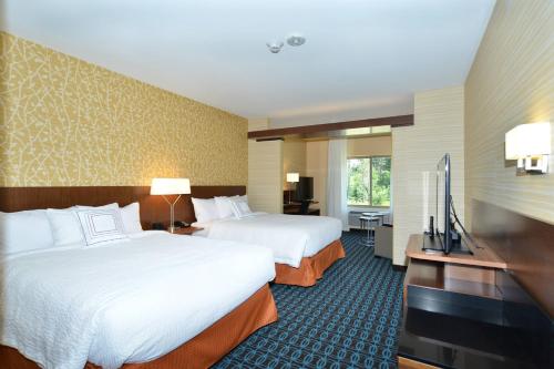 Fairfield Inn & Suites by Marriott Eau Claire/Chippewa Falls في أو كلير: غرفة فندقية بسريرين وتلفزيون بشاشة مسطحة
