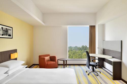 a hotel room with two beds and a desk and a window at Fairfield by Marriott Ahmedabad in Ahmedabad