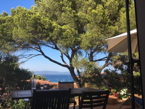 een tafel en stoelen met uitzicht op de oceaan bij Villa Les Quatre Vents mit traumhaftem Meerblick in Hyères