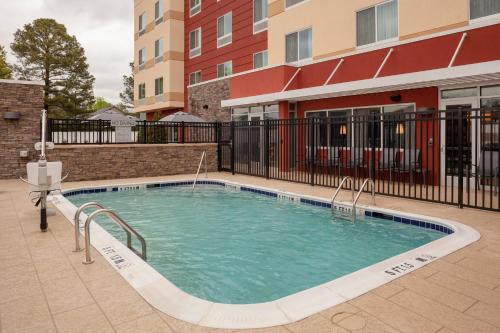 a swimming pool in the courtyard of a apartment building at Fairfield Inn & Suites by Marriott Augusta Washington Rd./I-20 in Augusta