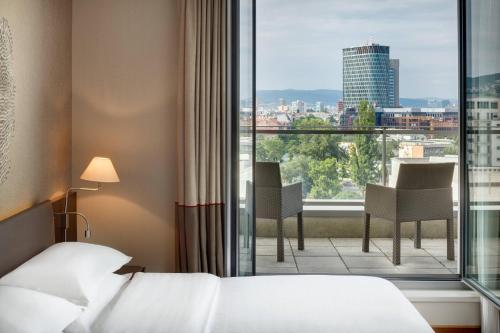 een hotelkamer met een bed en een groot raam bij Sheraton Bratislava Hotel in Bratislava