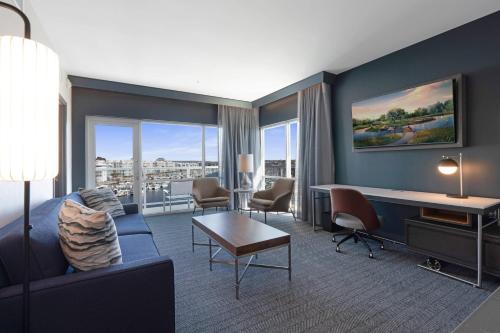 a hotel room with a couch and a desk and chairs at Courtyard by Marriott Marina del Rey in Los Angeles