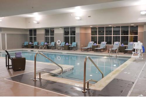 uma grande piscina com cadeiras e mesas em Residence Inn by Marriott Omaha Aksarben Village em Omaha