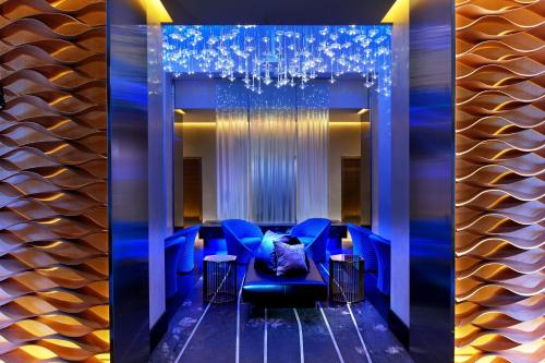a dining room with blue chairs and a chandelier at W Los Angeles – West Beverly Hills in Los Angeles