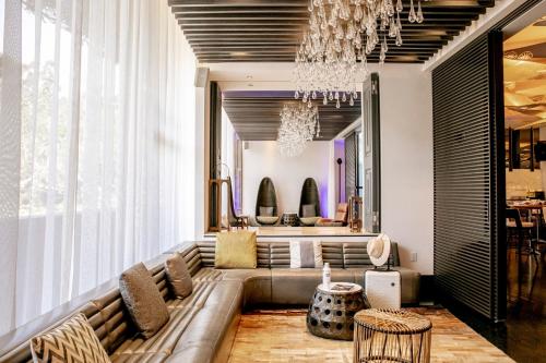 a living room with a couch and a chandelier at W Los Angeles – West Beverly Hills in Los Angeles