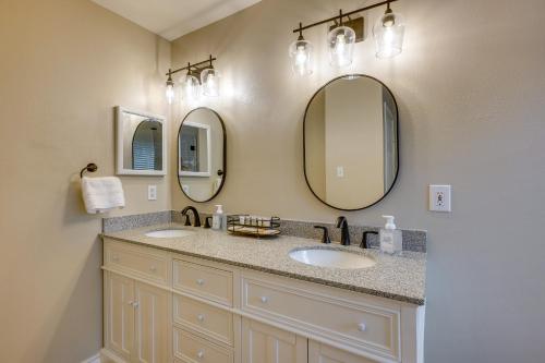 a bathroom with two sinks and two mirrors at Modern Woodlands Townhome with Spacious Yard and Patio in The Woodlands