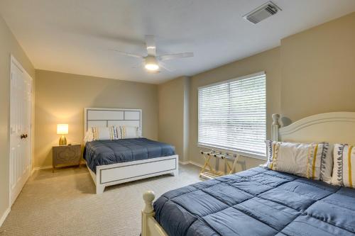 a bedroom with two beds and a window at Modern Woodlands Townhome with Spacious Yard and Patio in The Woodlands